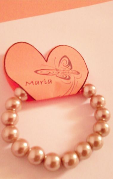 Pulseira de perolas beges.